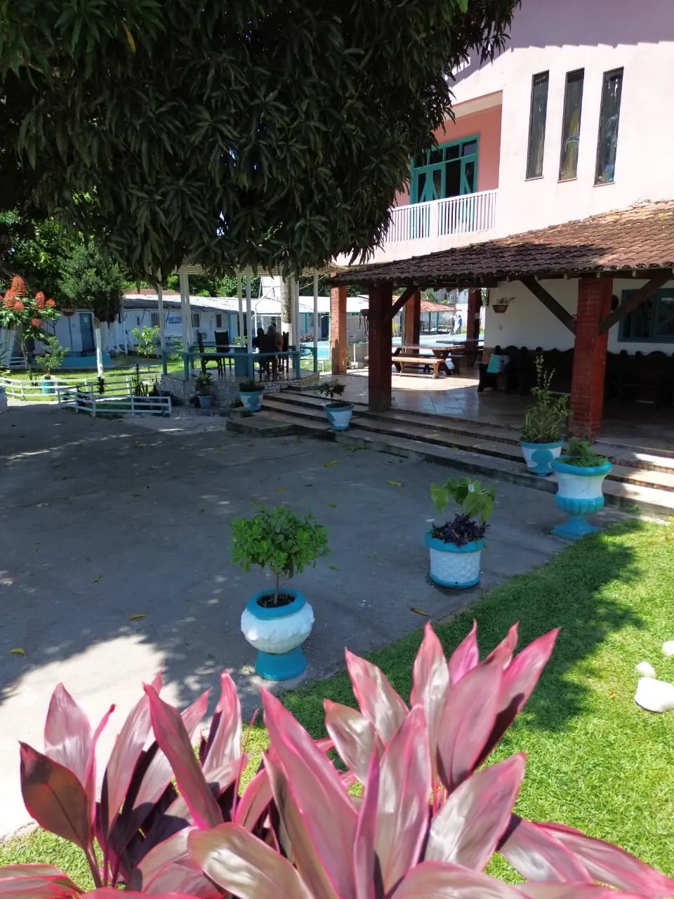 Varanda coberta e jardim frontal da comunidade