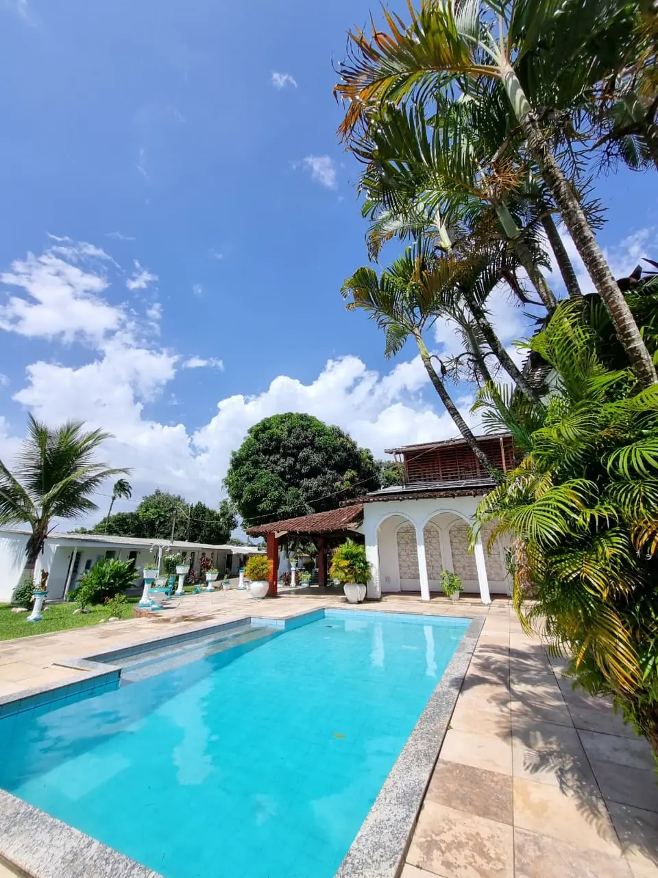 Área da piscina e fachada principal da comunidade